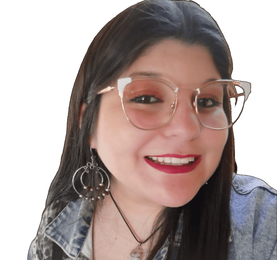 Person with glasses smiling, wearing statement earrings and a denim jacket.
